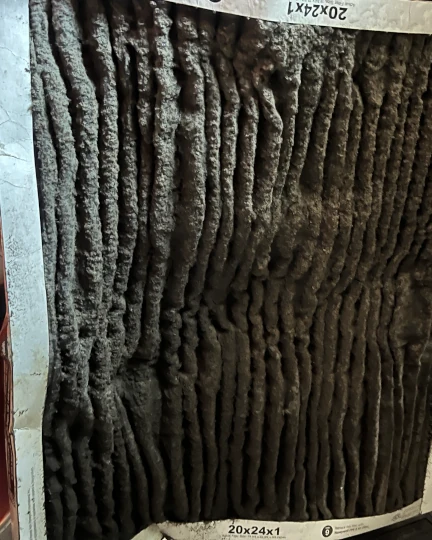 image of a very dirty air filter that caused air flow restriction and a sever air conditioner freeze up