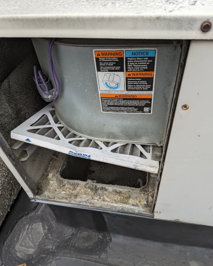 close up view of an air filter that came out of its track and got jammed into the blower causing an air flow problem and leading to a frozen AC